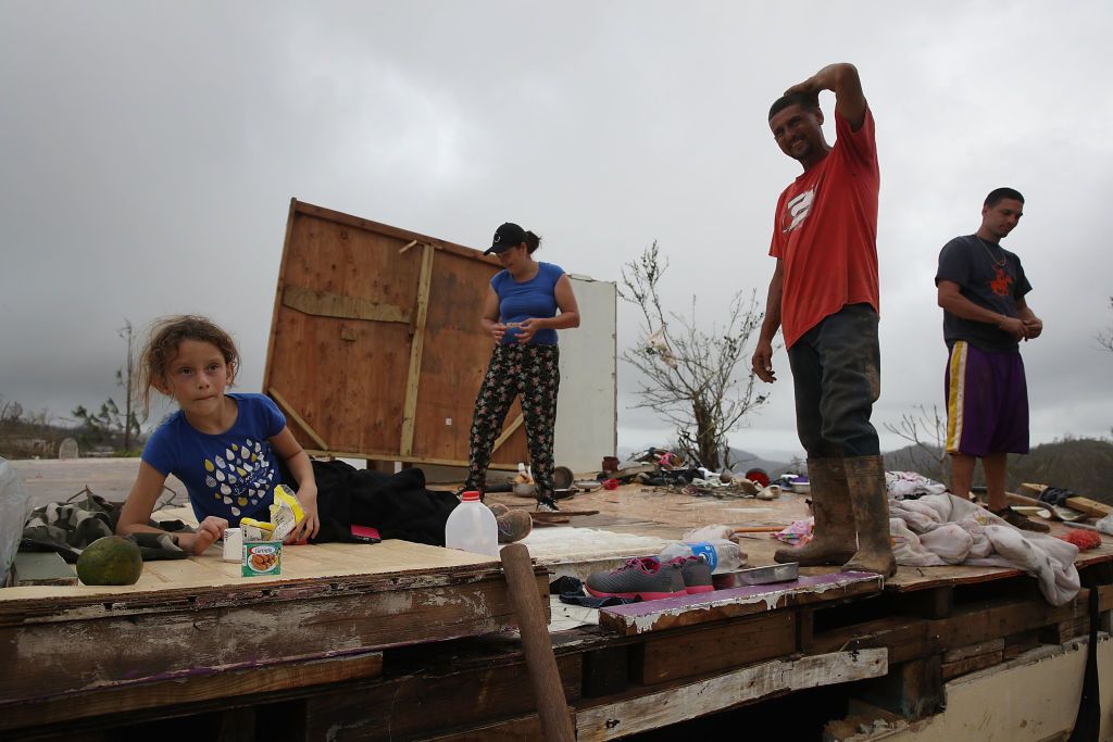 Karlian Mercado, 7, Carmen Maldonado, Carlos Flores and Jose Flores (L-R) stand on what remains of their home after it was blown away by Hurricane Maria as it passed through the area on September 24, 2017 in Hayales de Coamo, Puerto Rico. (Photo by Joe Raedle/Getty Images)